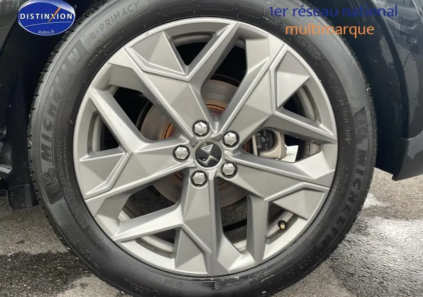 Gros plan sur la jante alliage 19'' Sapporo argentée du côté gauche d'une DS4 E-tense 225 noire.