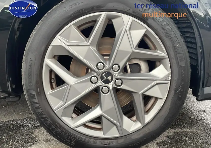 Gros plan sur la jante 19 pouces argentée du côté avant droit d'une DS4 E-tense 225 noire de 2023.