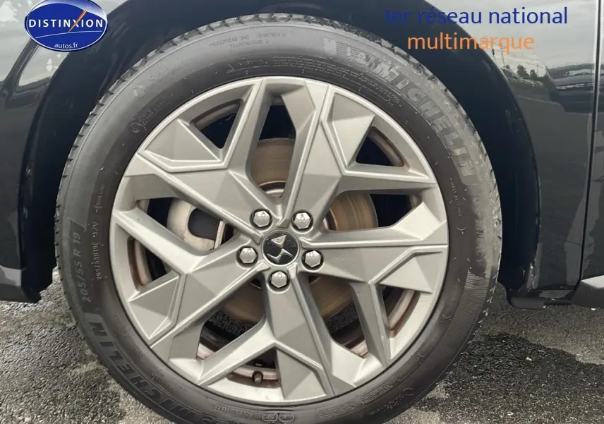 Gros plan sur la roue avant droite noire du DS4 E-tense 225 Cross Trocadero avec jante 19 pouces grise.