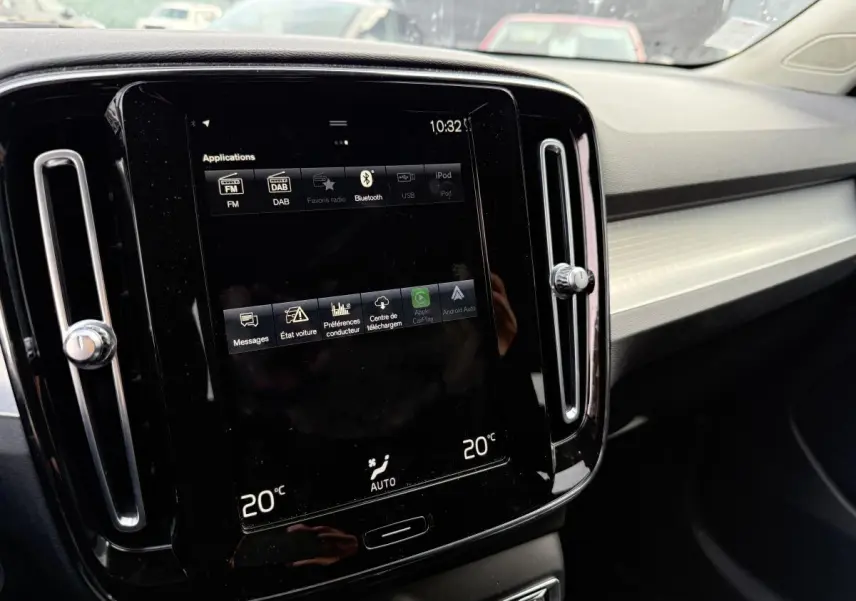 Écran tactile central noir du tableau de bord intérieur du Volvo XC40 Momentum blanc, affichant la climatisation à 20°C.