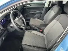 Intérieur du Volkswagen T-Cross 2024 bleu Sky Metal, vue côté conducteur sur les sièges en tissu et le tableau de bord moderne.