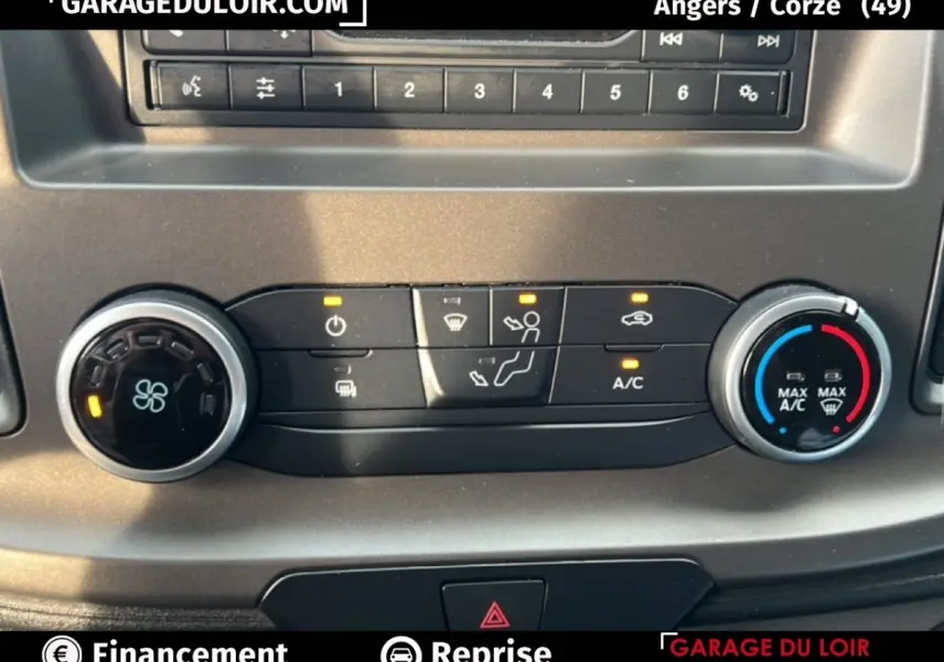 Gros plan sur la console de climatisation du Ford Transit Custom blanc, avec boutons et réglages éclairés.