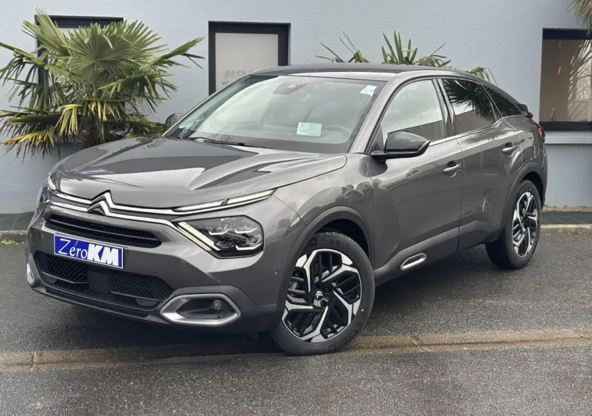 Citroën C4 Gris Platinium en 3/4 avant droit, avec jantes alliage et signature lumineuse LED distinctive.