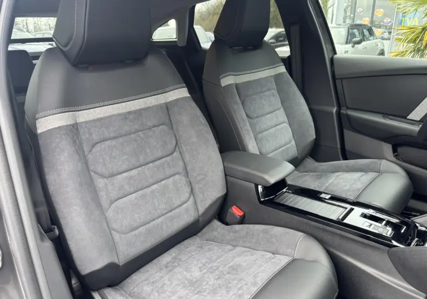 Vue intérieure des sièges avant en Alcantara gris avec accoudoir central et console brillante d'une Citroën C4 2024.