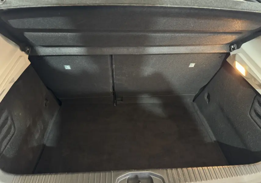 Vue intérieure du coffre noir ouvert d'une Renault Clio Business TCe 100 blanche de 2020, sans chargement visible.