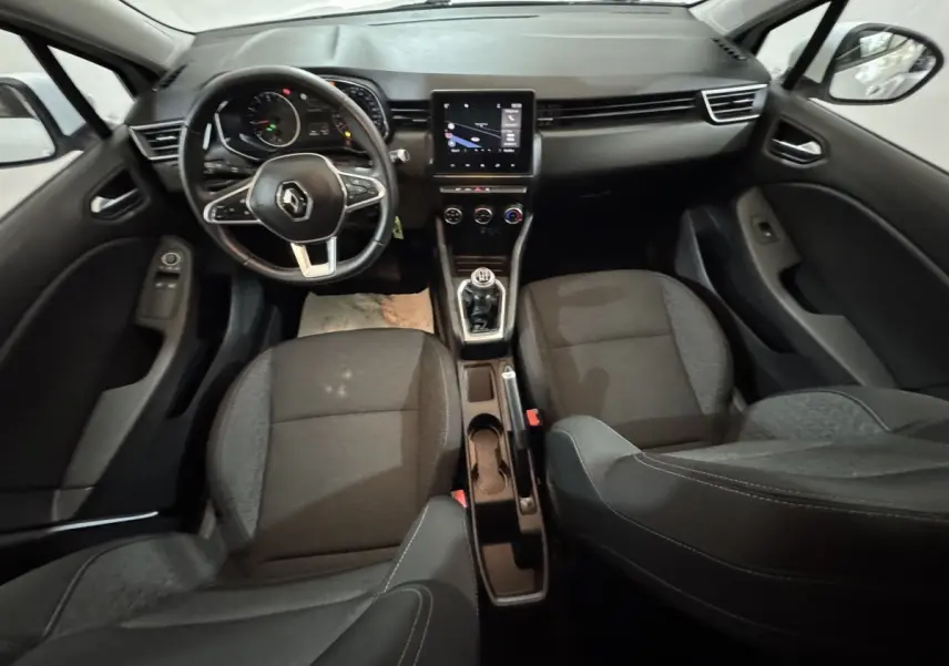 Vue intérieure avant de la Renault Clio Business TCe 100 2020, volant cuir, écran tactile central et sièges noirs.