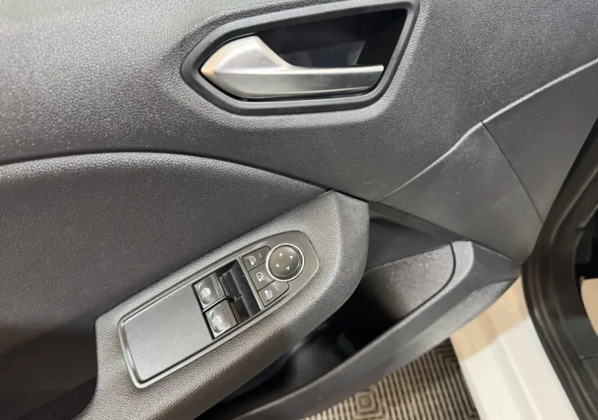 Détail de la porte avant gauche de la Renault Clio Business blanche, montrant les commandes de vitres et rétroviseurs.