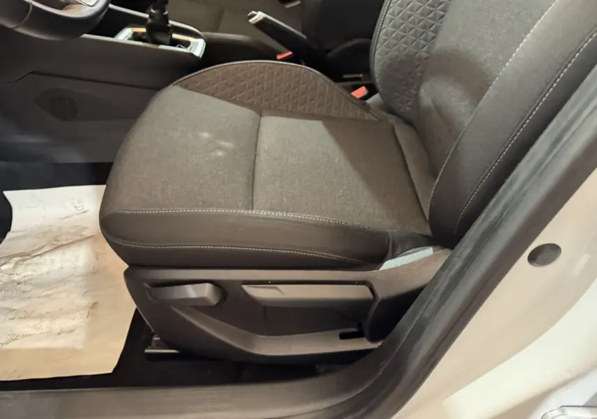 Vue rapprochée du siège avant droit gris foncé de la Renault Clio Business TCe 100 2020 avec portière blanche ouverte.