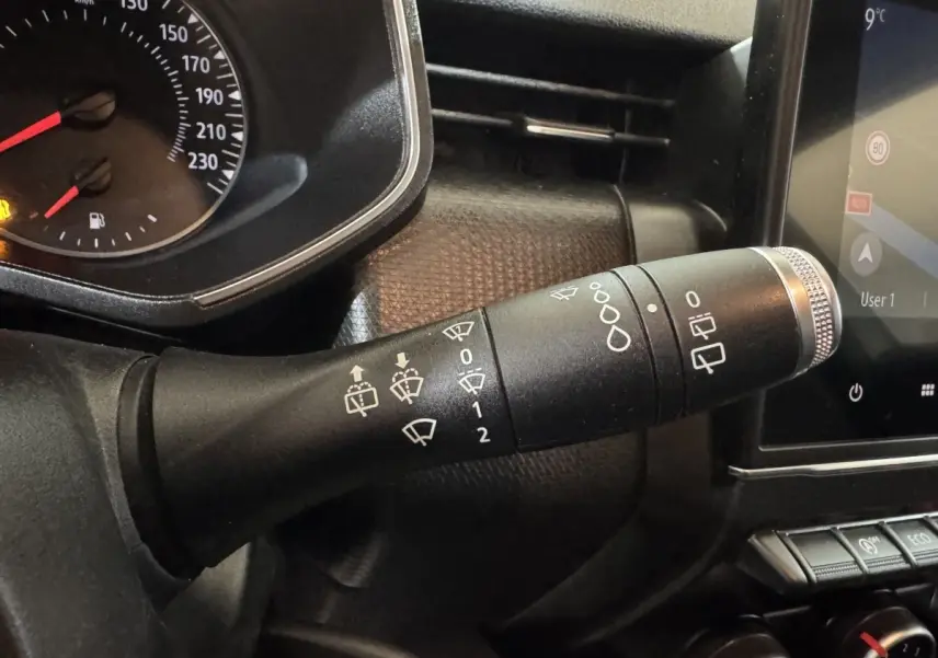 Gros plan sur la commande des essuie-glaces à gauche du tableau de bord noir de la Renault Clio Business TCe 100 blanche de 2020.