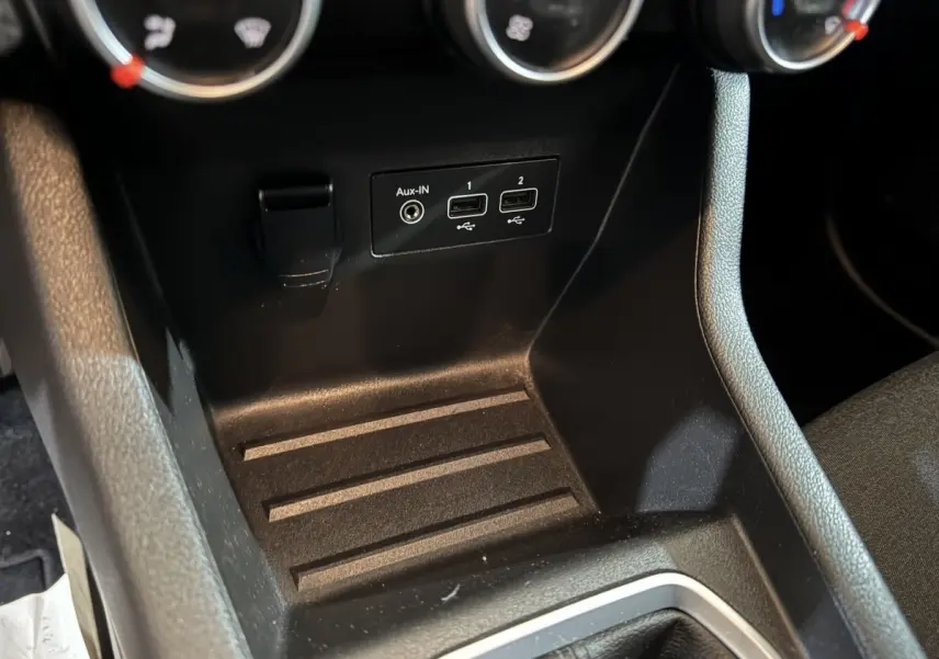Vue rapprochée de la console centrale noire de la Renault Clio Business TCe 100 avec prises USB et entrée Aux-IN.