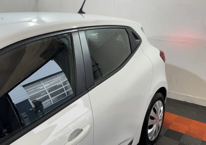Vue arrière côté droit d'une Renault Clio blanche Business TCe 100, avec poignées de porte intégrées et jantes acier.