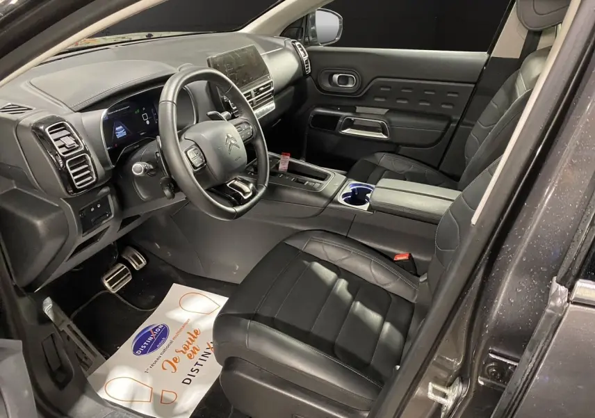 Intérieur avant droit du Citroën C5 Aircross gris platinium 2023 avec sièges noirs en cuir et tableau de bord moderne.