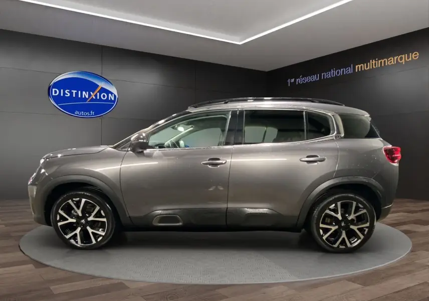 Profil latéral droit d'un Citroën C5 Aircross gris platinium 2023 avec jantes alliage noires et toit panoramique.