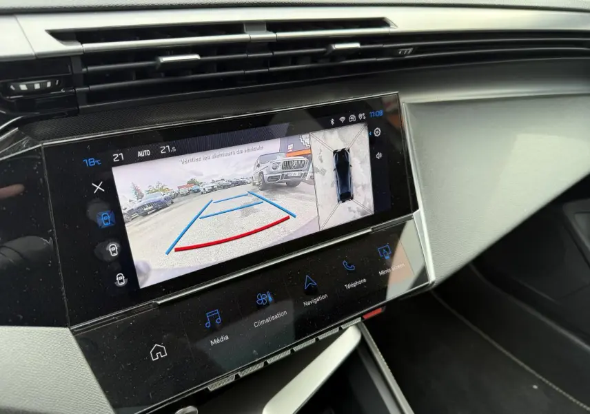 Écran tactile central affichant la caméra de recul et la vue 360° dans l'habitacle d'une Peugeot 408 blanche.