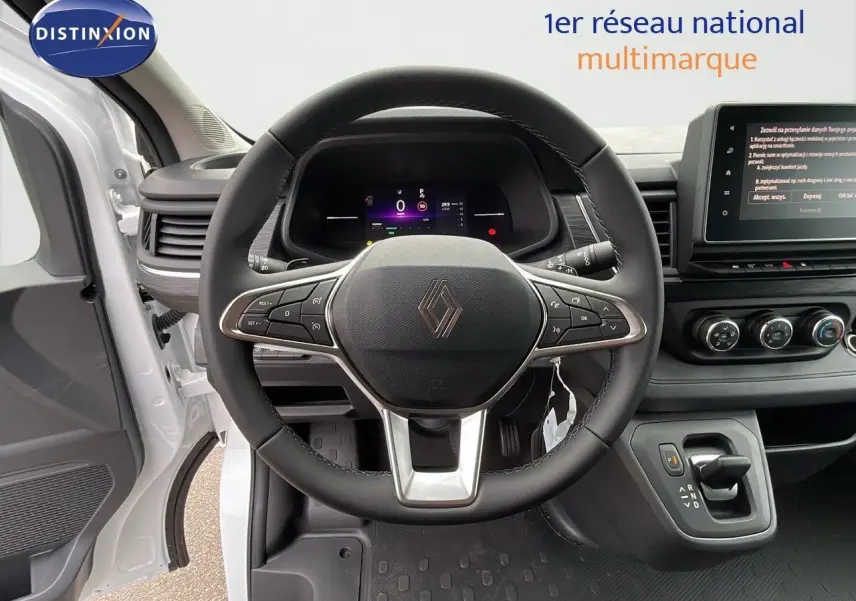Vue intérieure centrée sur le volant du Renault Trafic blanc glacier 2025 avec tableau de bord numérique et écran tactile.