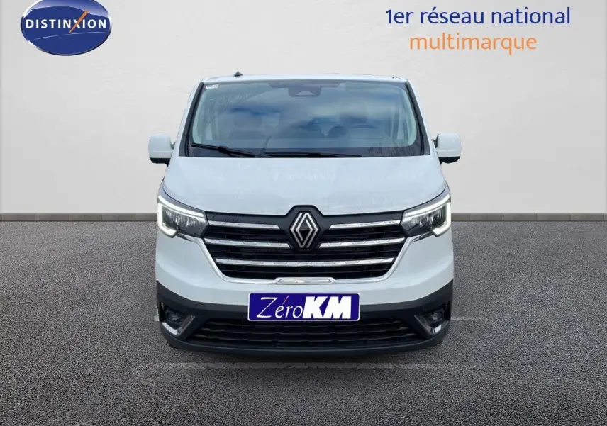 Vue frontale d'un Renault Trafic Fourgon blanc glacier 2025 avec calandre chromée et phares LED allumés.