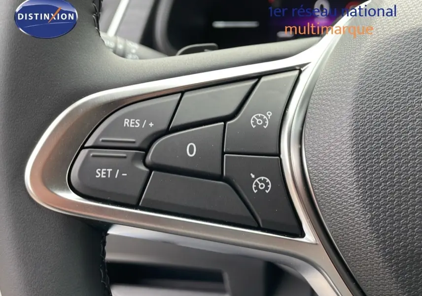 Gros plan sur les commandes de régulateur de vitesse au volant du Renault Trafic Fourgon blanc glacier.