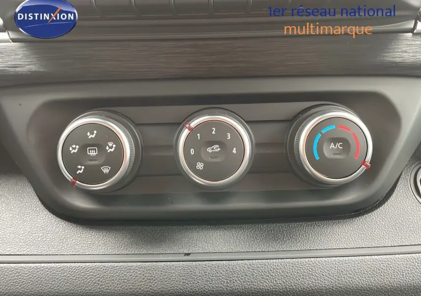 Gros plan sur les commandes de climatisation du Renault Trafic Fourgon blanc glacier, avec réglages manuels et air conditionné.