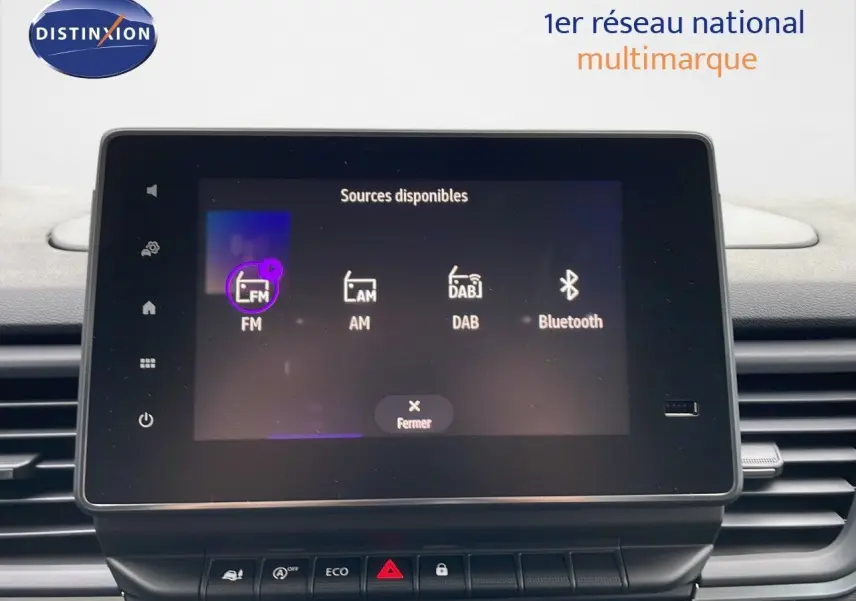 Écran tactile central du tableau de bord du Renault Trafic blanc glacier, affichant les sources audio disponibles.