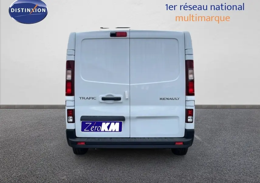 Vue arrière d'un fourgon Renault Trafic blanc glacier avec portes battantes et feux arrière verticaux.
