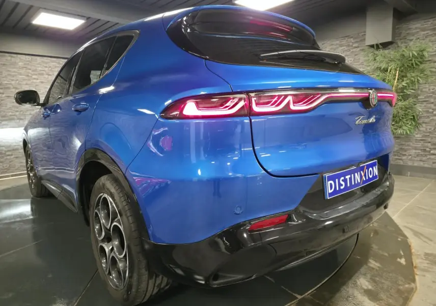 Vue 3/4 arrière droite de l'Alfa Romeo Tonale bleu avec feux arrière LED et jantes alliage 18 pouces.
