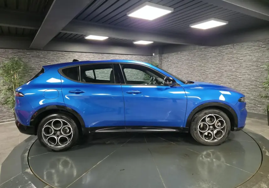 Vue de profil côté gauche d'une Alfa Romeo Tonale Sprint 2025 bleu métallisé avec jantes alliage distinctives.