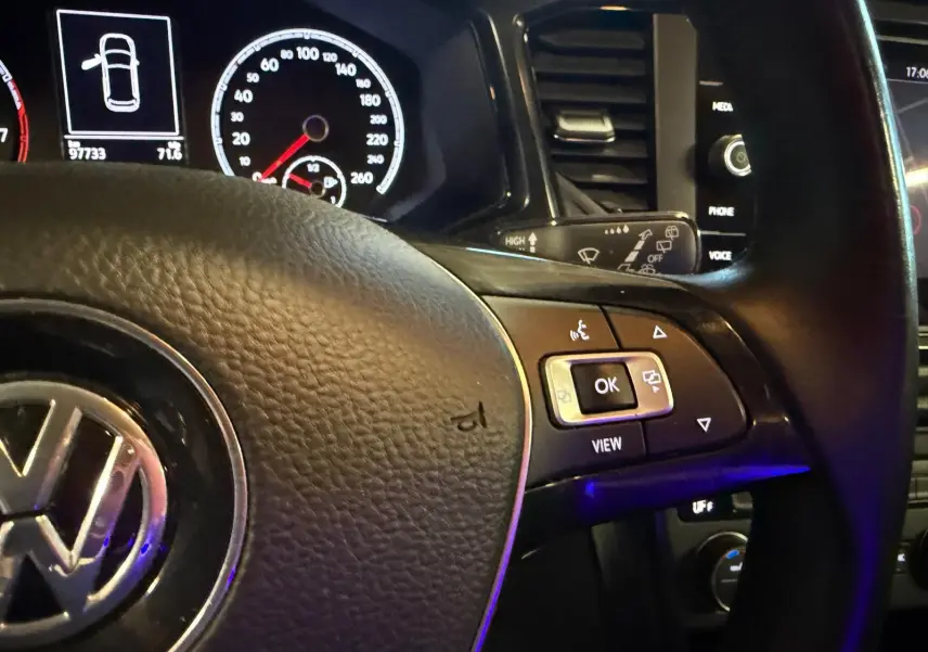 Gros plan sur le volant multifonctions en cuir du Volkswagen T-Roc 2019 avec tableau de bord et commandes visibles.