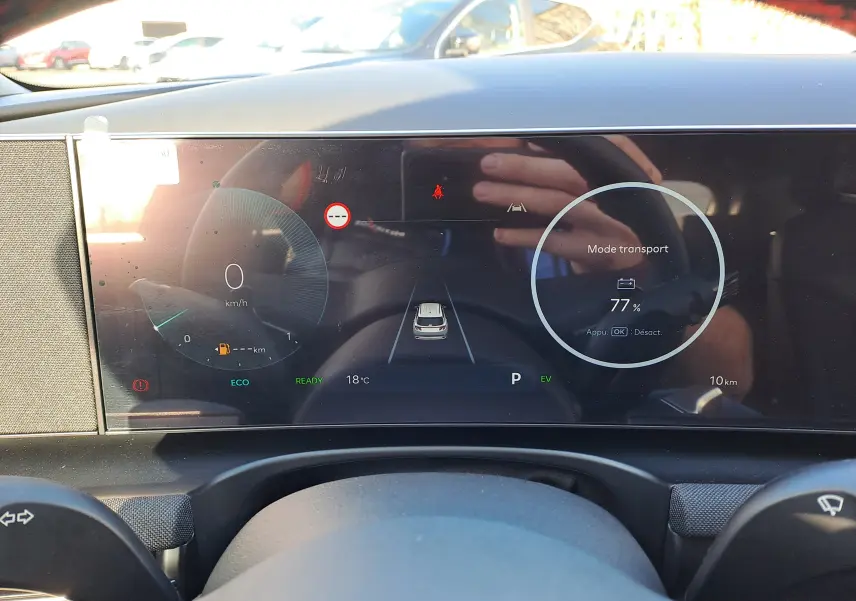 Tableau de bord numérique du Hyundai Tucson 2025 affichant la vitesse à 0 km/h et batterie à 77% en mode transport.