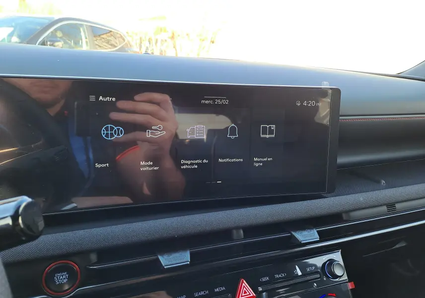 Vue intérieure du tableau de bord du Hyundai Tucson 2025, écran tactile central avec menu et bouton start/stop rouge visible.