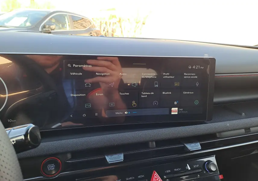 Vue intérieure du tableau de bord du Hyundai Tucson 2025 noir, avec écran tactile central et bouton start/stop rouge.