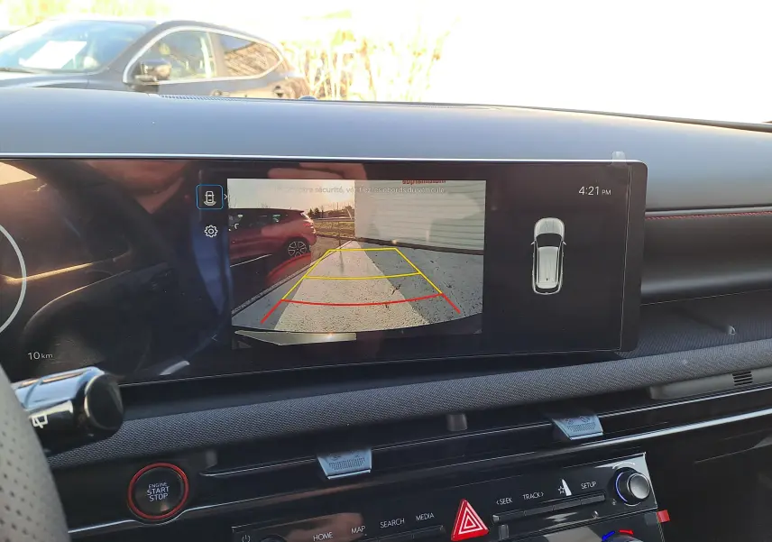 Vue intérieure du tableau de bord du Hyundai Tucson 2025 avec écran de caméra de recul affichant l'arrière du véhicule en Abyss Black.