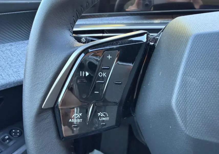 Gros plan sur les commandes noires au volant côté gauche du Peugeot 3008 Hybrid 145 e-DCS6 Allure bleu 2025.