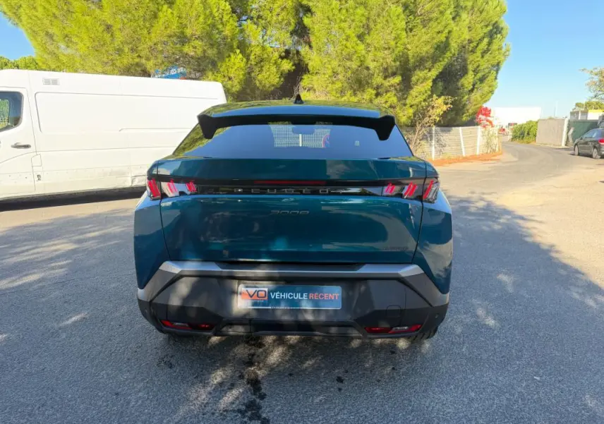 Vue arrière du Peugeot 3008 Hybrid 145 e-DCS6 Allure bleu 2025, avec feux arrière à griffes distinctifs et toit noir.