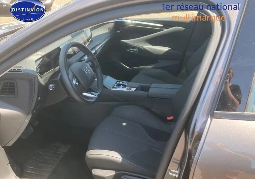 Intérieur de la DS4 E-tense 225 gris platinium, vue côté conducteur avec volant cuir et console centrale moderne.