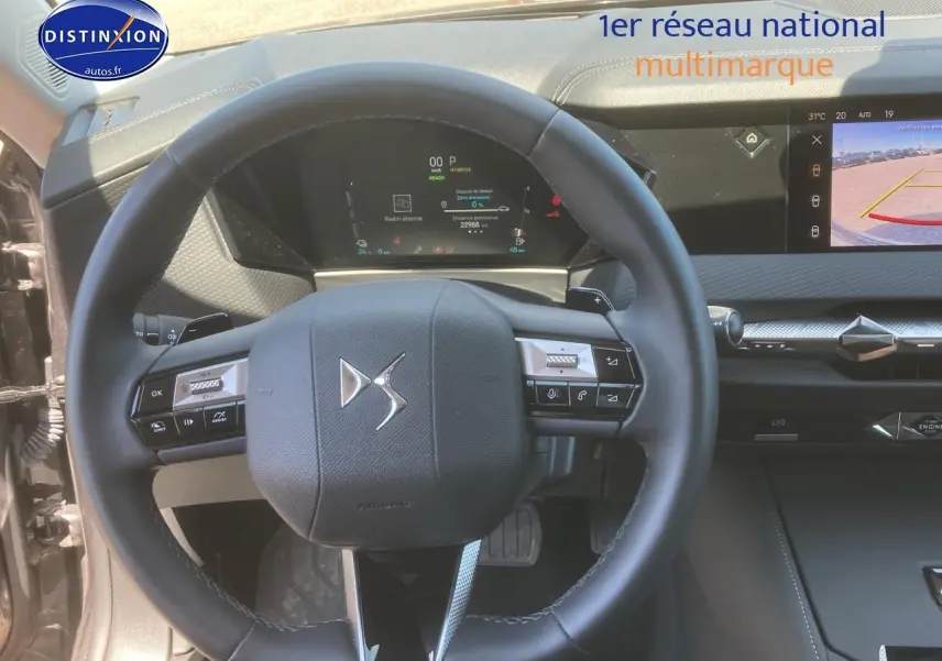 Vue intérieure centrée sur le volant cuir DS d'un DS4 E-tense 225 gris platinium avec tableau de bord numérique et écran tactile.