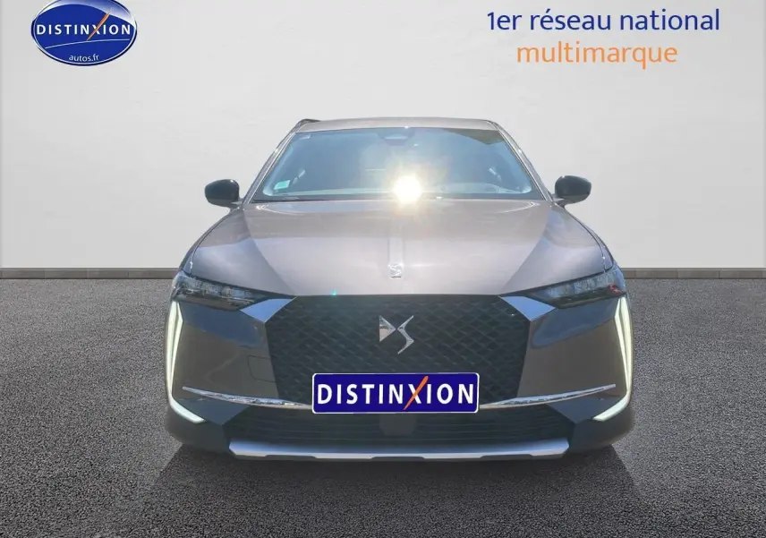Vue frontale du DS4 E-tense 225 Cross Trocadero gris platinium avec calandre noire et feux LED verticaux allumés.