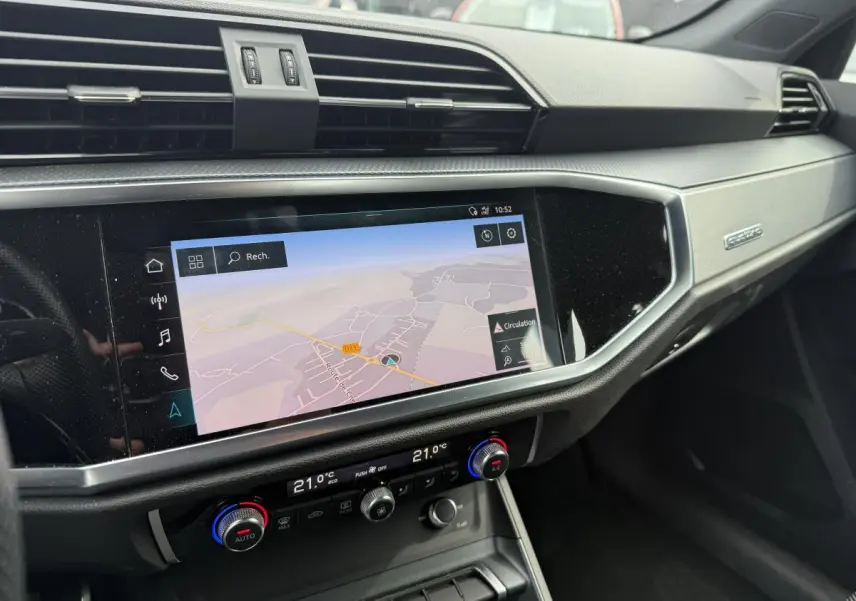 Détail de la console centrale avec écran tactile de navigation et commandes de climatisation dans l'Audi Q3 S Line noir 2019