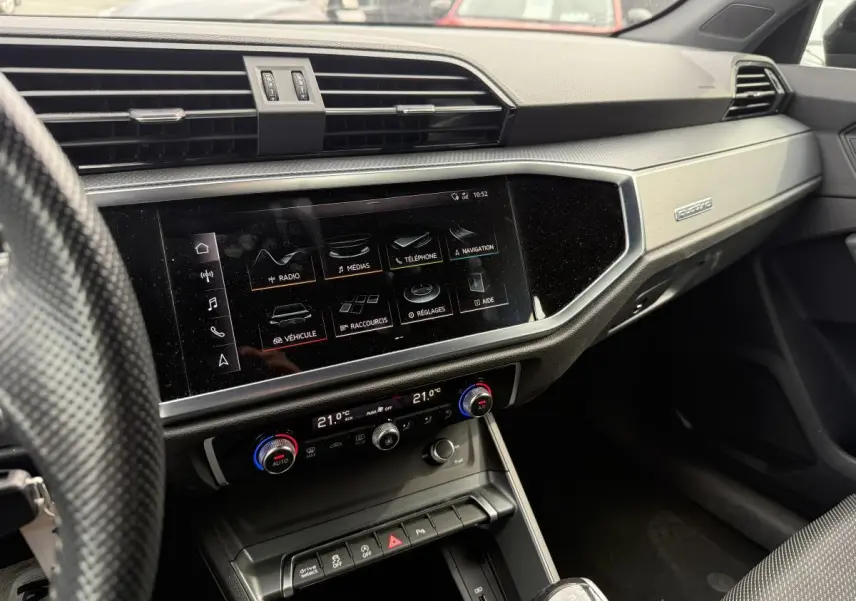 Tableau de bord et console centrale de l'Audi Q3 S Line 2019, avec écran tactile et commandes climatisation visibles.