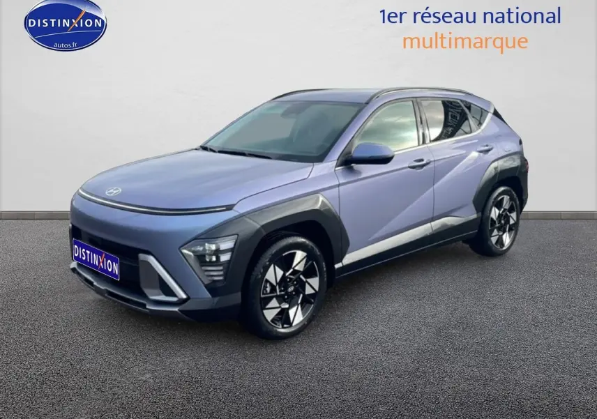 Hyundai Kona 2025 bleu en 3/4 avant droit avec jantes alliage et protections noires sur ailes et bas de caisse.