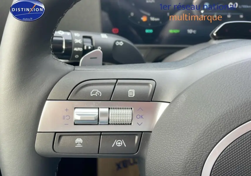 Gros plan sur les commandes multifonctions côté gauche du volant cuir du Hyundai Kona 2025 hybride bleu.