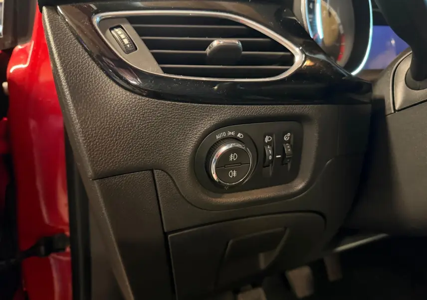 Gros plan sur la commande des phares et aérateur côté gauche d’un Opel Astra rouge 2016.