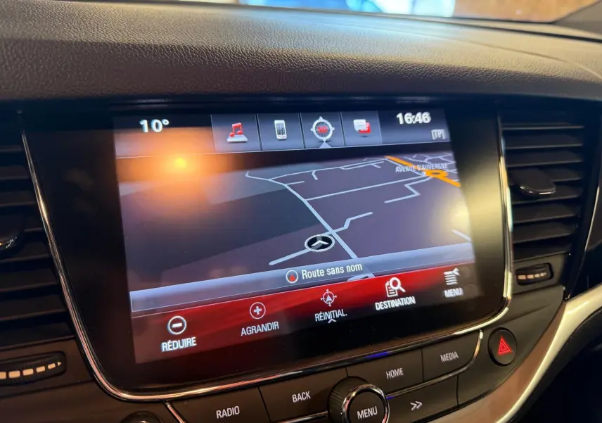 Écran tactile central de la console de l’Opel Astra rouge, affichant la navigation GPS en gros plan.