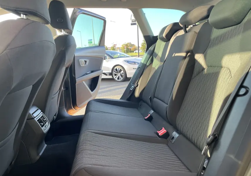 Vue intérieure arrière droite sur les sièges en tissu gris noir d'une SEAT LEON ST 2013 avec porte ouverte côté droit.