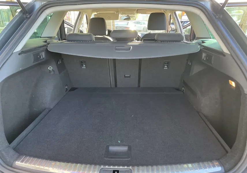 Coffre spacieux ouvert vu de l'arrière d'une SEAT LEON ST gris, avec banquette arrière et cache-bagages visibles.