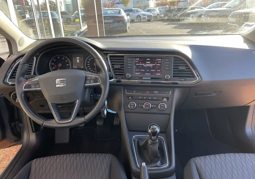 Intérieur gris noir de la SEAT LEON ST 2013, vue frontale du tableau de bord avec volant, écran tactile et boîte manuelle.