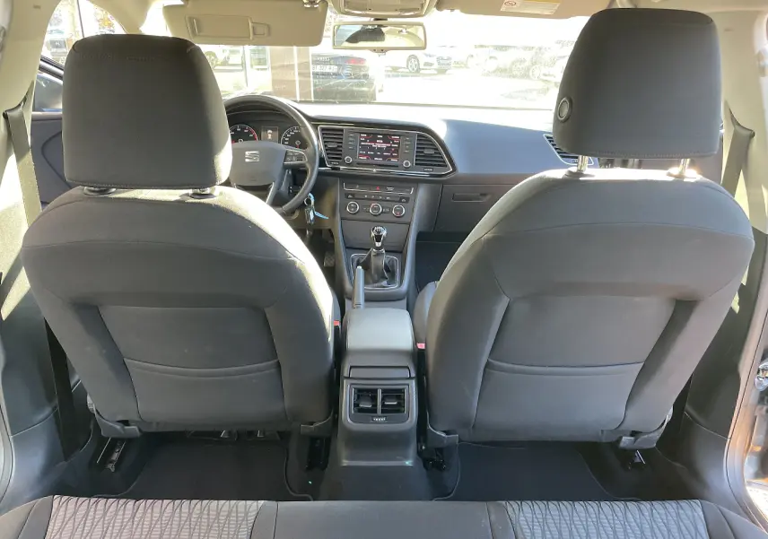 Intérieur noir et gris du SEAT LEON ST 2013, vue arrière des sièges avant et tableau de bord avec boîte manuelle.