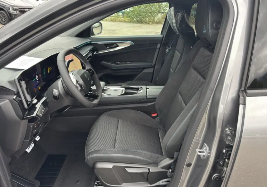 Intérieur avant droit du Renault Austral E-Tech 200 Esprit Alpine Plus 2025, sièges noirs avec surpiqûres bleues et tableau de bord numérique.