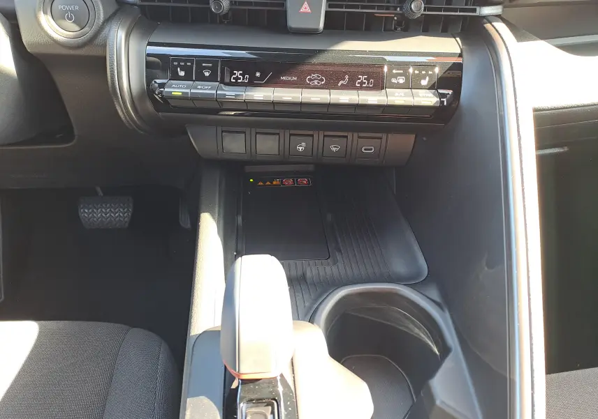 Vue intérieure centrée sur la console centrale du Toyota C-HR gris minéral, avec levier de vitesse et commandes climatisation.