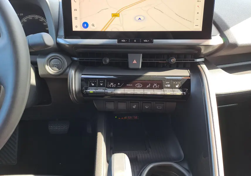 Vue intérieure du tableau de bord du Toyota C-HR gris minéral 2025, avec écran tactile et commandes climatisation digitales.