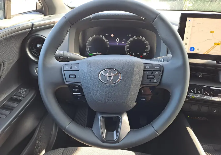 Vue centrée sur le volant noir du Toyota C-HR 2025 avec tableau de bord numérique et écran tactile à droite.